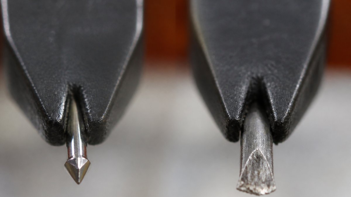 Close-up of a turntable stylus under magnification showing a pristine diamond tip with sharp profile next to a visibly worn stylus with a flattened, scratched surface