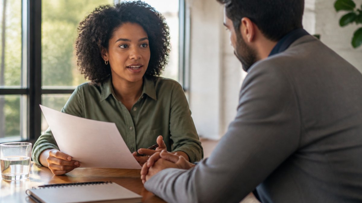 Young professional discussing a printed document with their manager in a bright, modern office setting