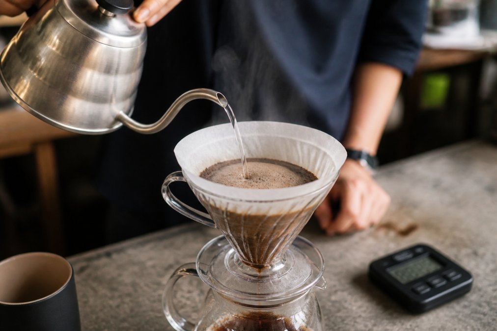Infographic showing the bloom phase process to brew single origin coffee using a pour-over dripper and timer.