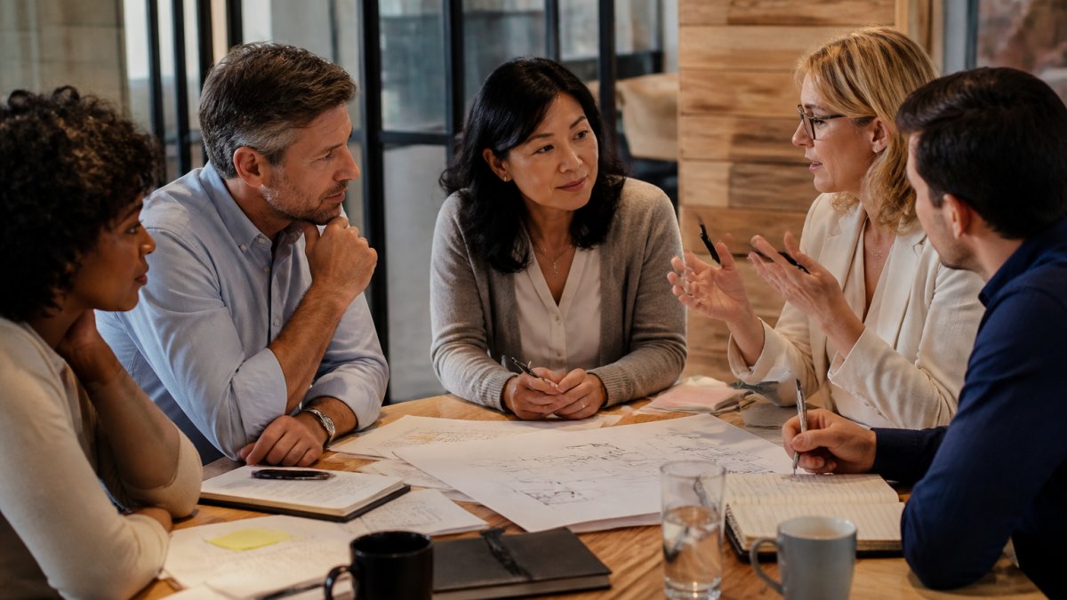 Diverse leadership team mapping out a framework to bridge the strategic execution gap during a meeting.
