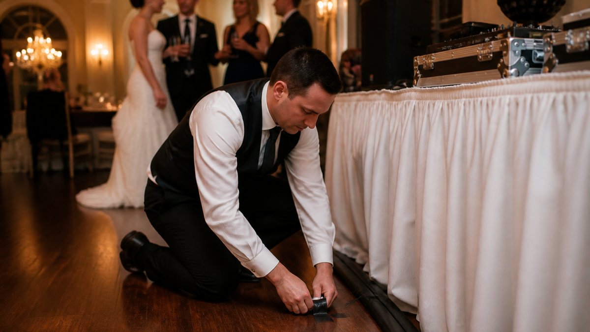 Infographic detailing a wedding entertainment backup plan with a DJ securing cables during a reception