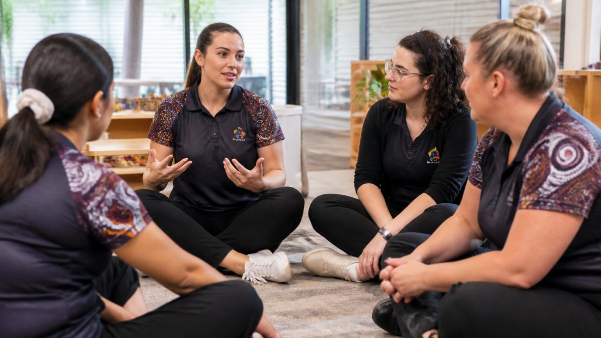 Early learning educators in a circle listening to a colleague to help build psychological safety in childcare teams