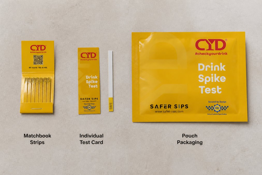 Flat lay of multiple drink testing kit products including matchbook strips, individual test cards, and pouch packaging arranged on a neutral surface with clear labelling visible