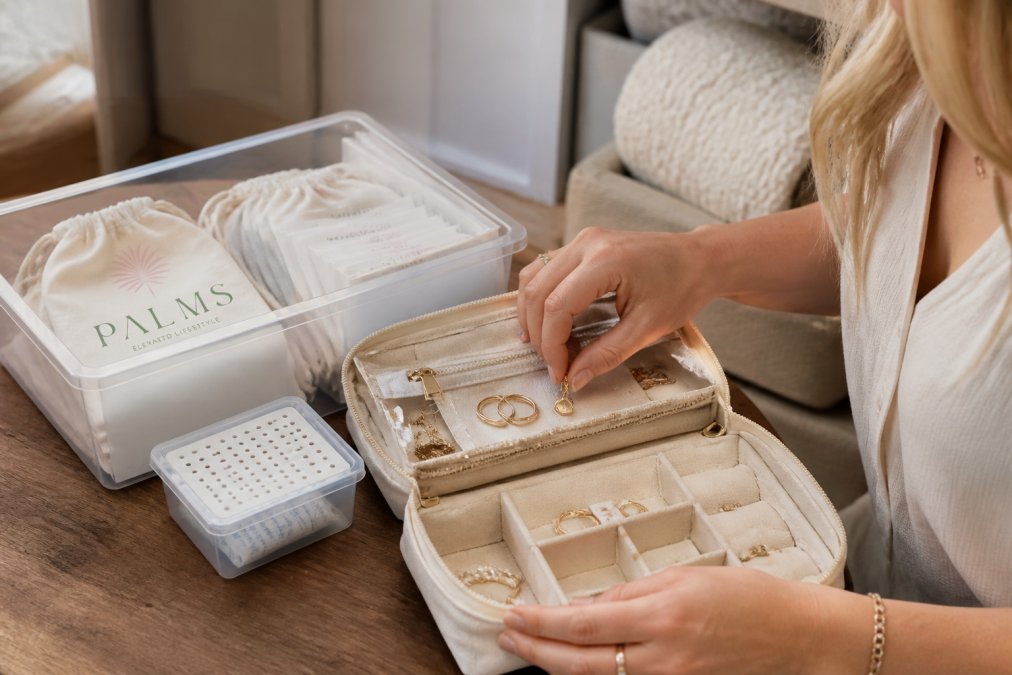 Organized protective storage pouch and container displaying handcrafted jewelry pieces arranged neatly, with anti-tarnish strips visible and humidity-control elements in place