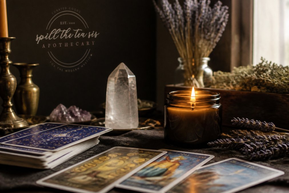 A tarot deck spread on an altar with a lit intention candle and dried herbs to help you choose a tarot deck.