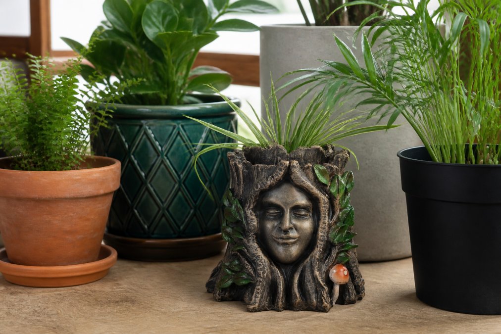 Close-up collection of different plant pot materials arranged together: terracotta, ceramic glazed, plastic, and concrete pots with various plants, showing texture and finish differences in natural light
