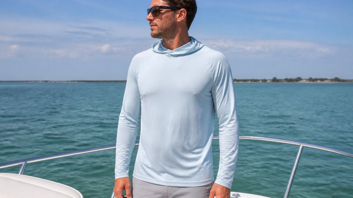 Person wearing a lightweight UPF 50+ sun shirt outdoors on a boat deck, demonstrating proper fit with visible sleeve length, collar coverage, and relaxed but secure fit in natural daylight