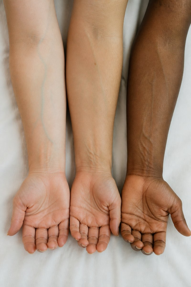 Close-up of diverse skin tones showing cool, warm, and neutral undertones in natural daylight, with wrist veins visible to demonstrate undertone identification