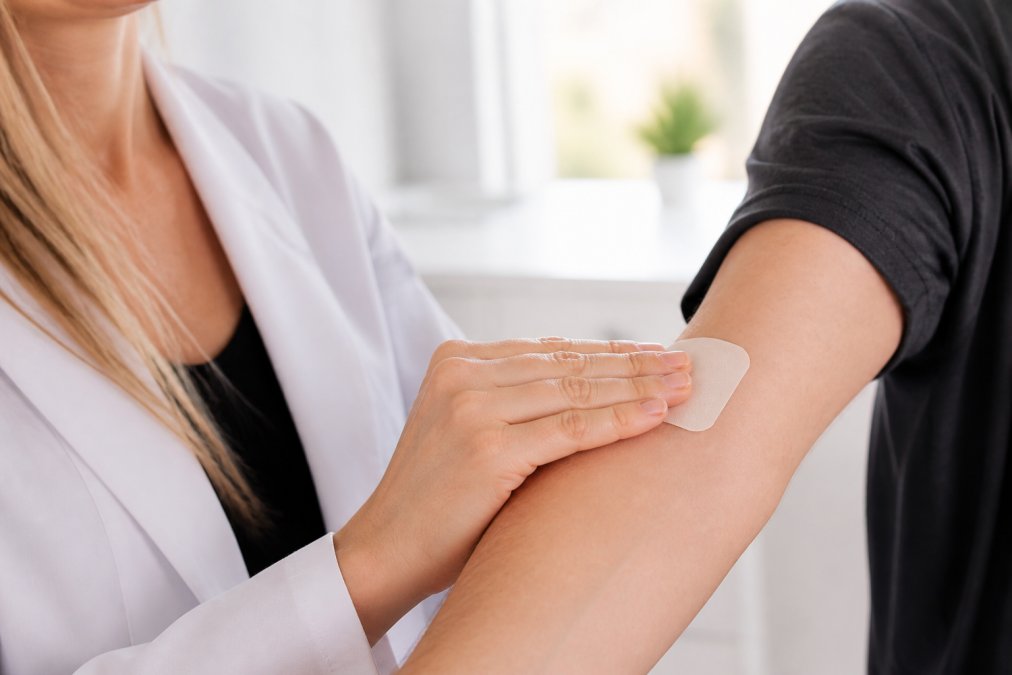 Professional demonstrating proper CBD patch application technique on clean forearm skin with patch positioned correctly, showing optimal placement angle and adhesion