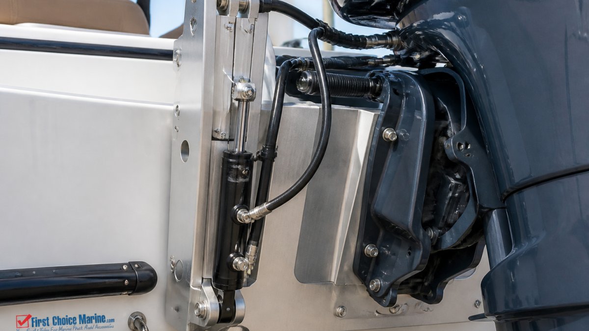 Close-up of a jack plate mounted on a boat transom with an outboard engine, showing the mounting hardware, hydraulic lines, and vertical adjustment mechanism in bright daylight