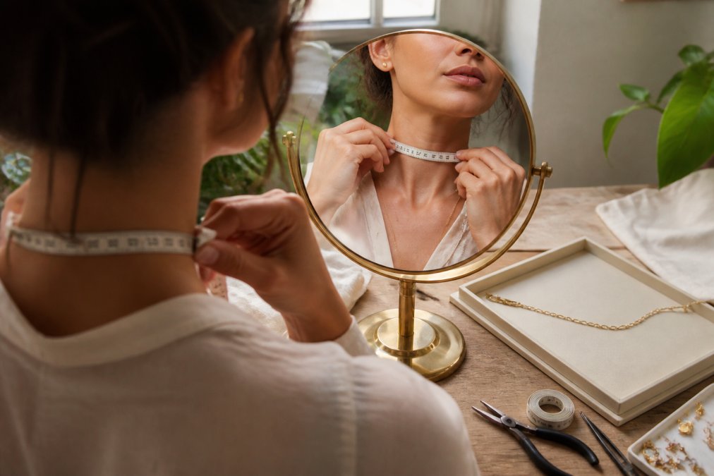 Woman using a soft measuring tape to measure her neck size for the right chain length for petite frames