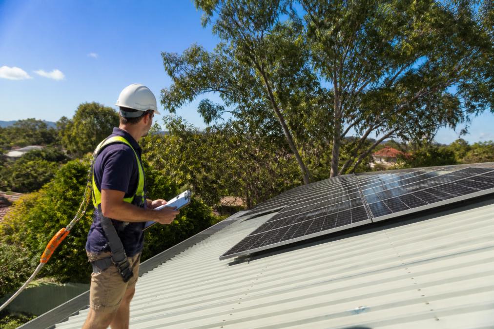 Electrician inspecting a roof for solar panels to help you learn how to choose the right solar system for your home.