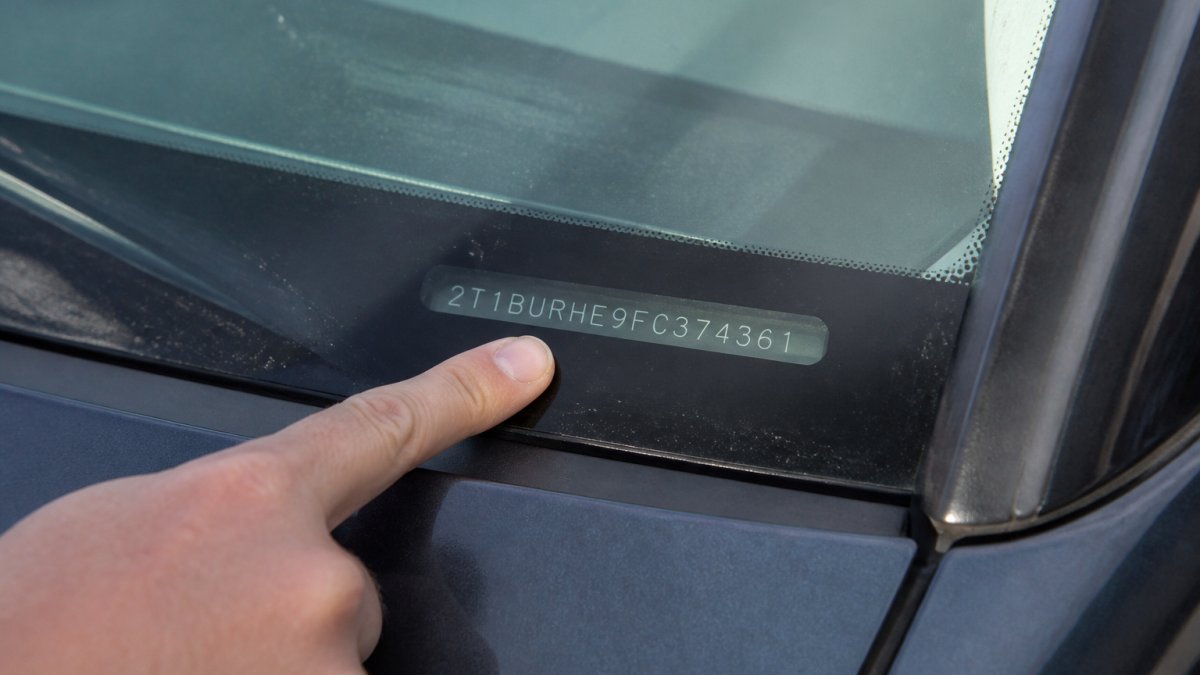 Diagram illustrating how to locate the 17-character vehicle identification number on the windshield corner.