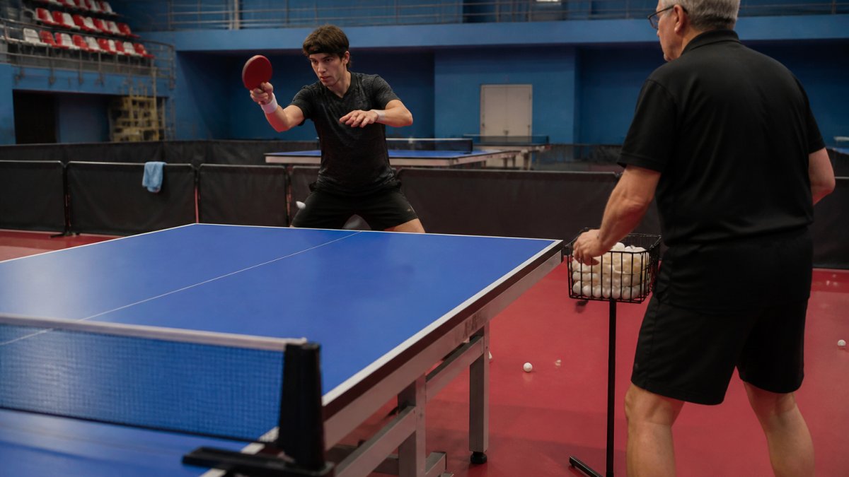 Diagram illustrating a table tennis training routine with a coach feeding balls to a player practicing forehands.
