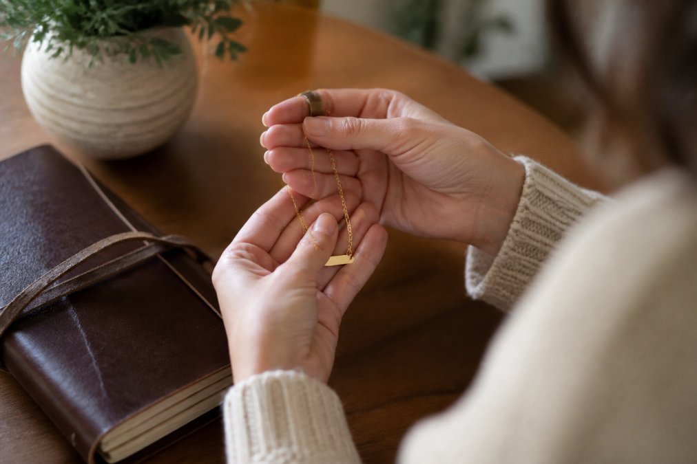 Infographic showing steps to customize jewelry with names, dates, and symbols on gold pendants