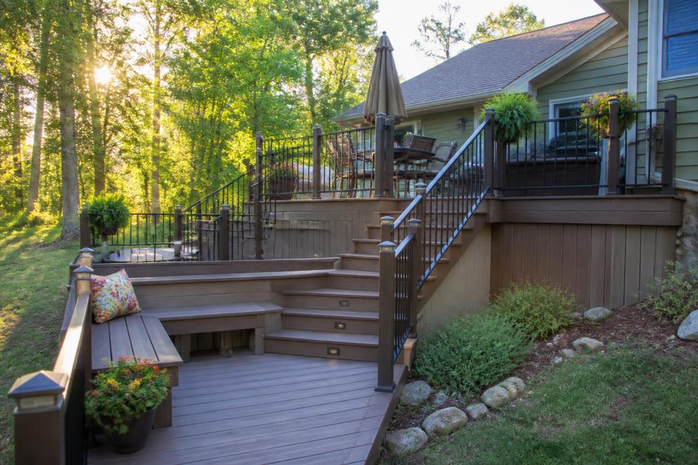 Multi-level composite deck transforming an awkward backyard deck into a sunny tiered outdoor living space.