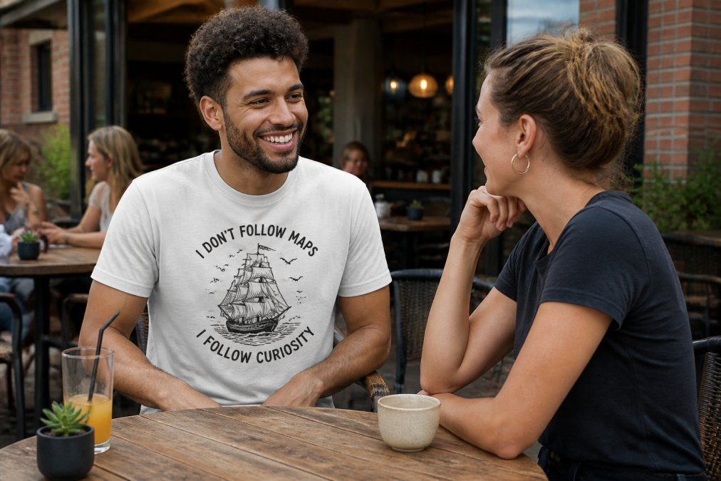 A person wearing a graphic t-shirt with a witty slogan, smiling and engaged in conversation with a friend at a casual outdoor cafe