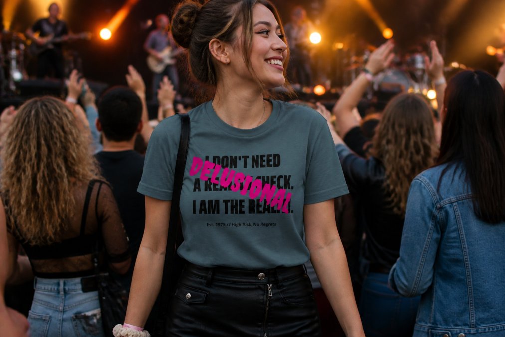 Person wearing a custom graphic tee styled with complementary pieces at a concert or fan event, surrounded by other fans, showcasing the finished apparel in a real-world setting with stage lighting