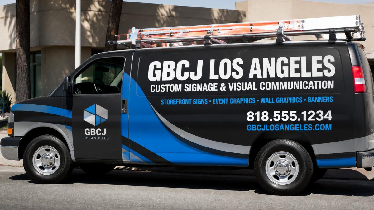 Professional service vehicle with full side wrap displaying company name in bold white letters, logo on driver's door, phone number and website in contrasting color, parked in bright daylight showing clear readability from distance