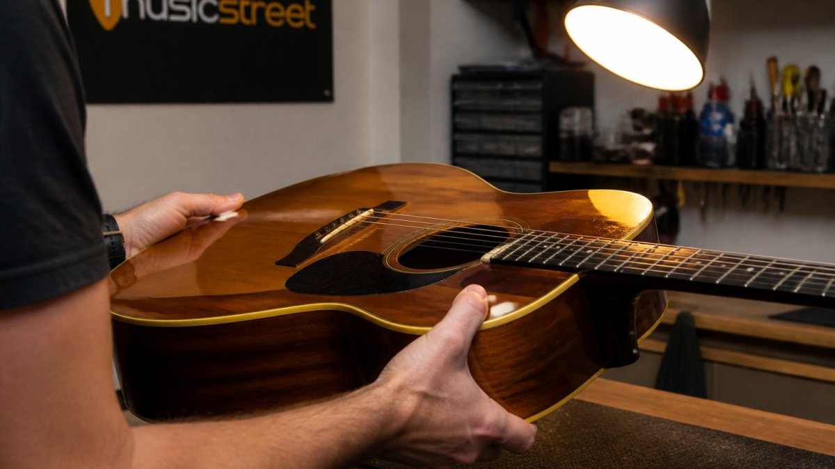 Step-by-step diagram illustrating how to inspect an acoustic guitar body and fretboard for condition grading.