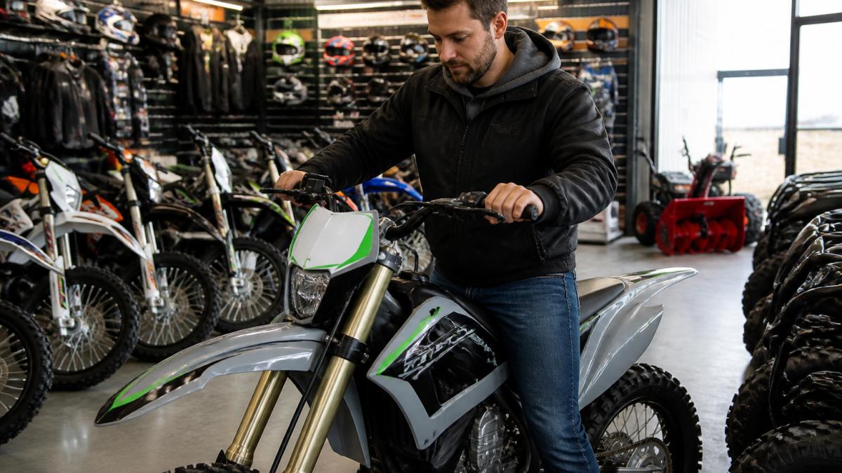 Customer testing an electric dirt bike near me in a showroom display