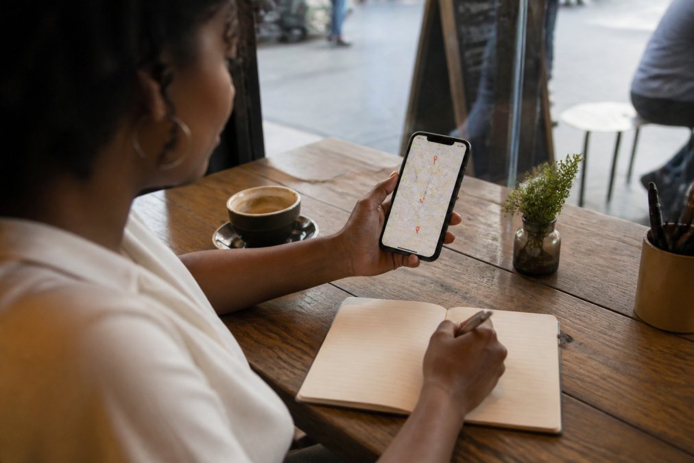 Smartphone map interface showing locations of local black-owned businesses while sitting at a cafe table