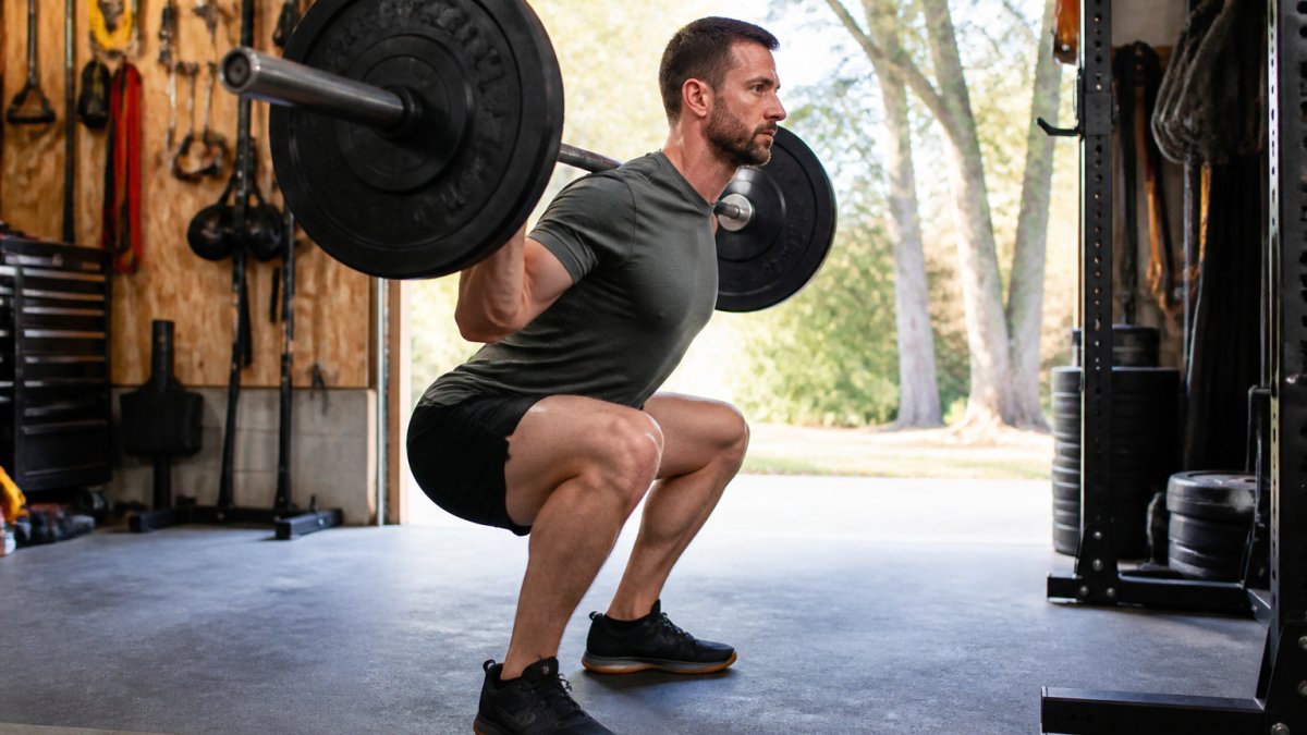 Lifter performing a barbell squat with neutral spine alignment to avoid common lifting form mistakes