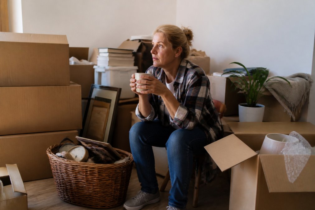 Infographic showing a person pausing during an estate cleanout to manage emotional stress while organizing belongings.