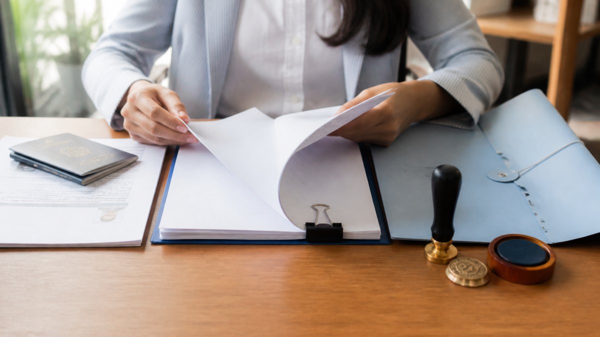 Person organizing a passport and documents with a notary seal for notarization before apostille processing