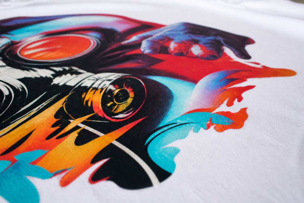 Close-up of authentic DTG graphic tee print showing crisp edges, vibrant color saturation, and clean detail with sharp boundaries between design elements on white cotton fabric