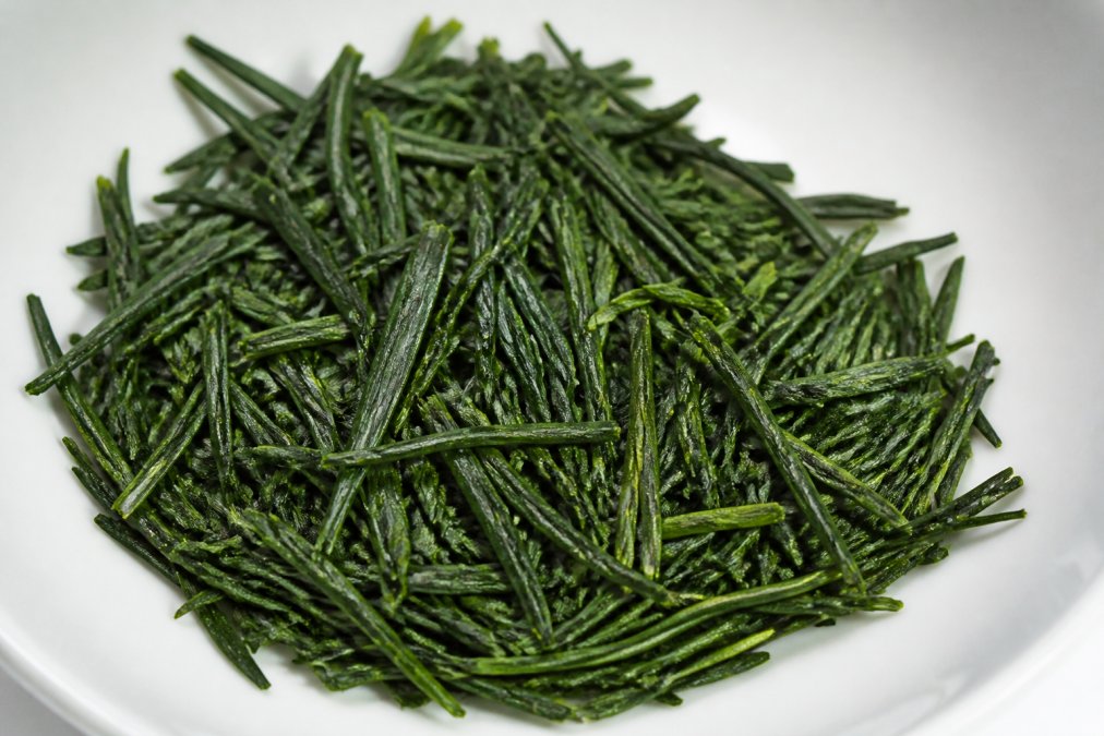 Infographic showing needle-like, glossy green leaves used to identify high quality organic sencha by visual inspection.