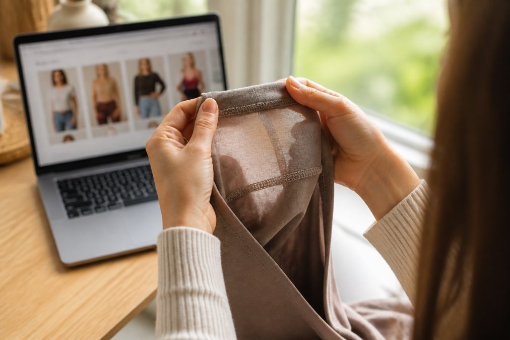 Hands examining internal seams to identify quality clothing construction methods
