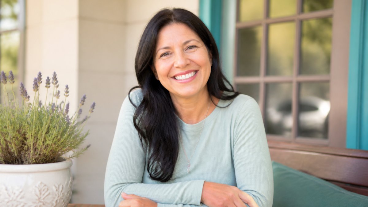 Woman smiling naturally in bright, welcoming environment displaying positive body language and relaxed facial expression