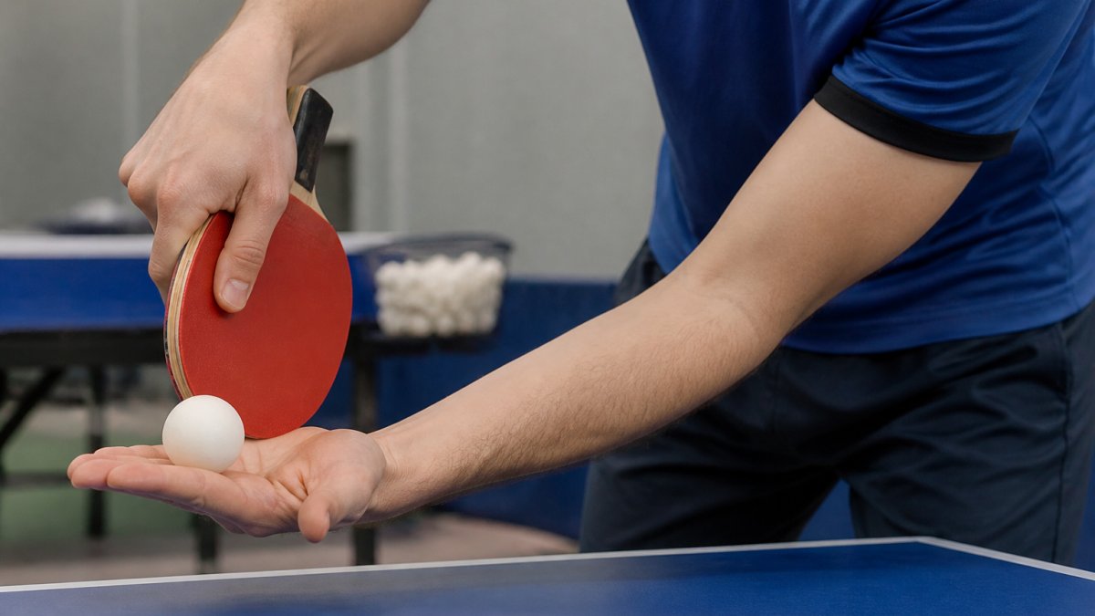 Diagram demonstrating the grip and brush motion to improve table tennis serve spin with backspin contact points.