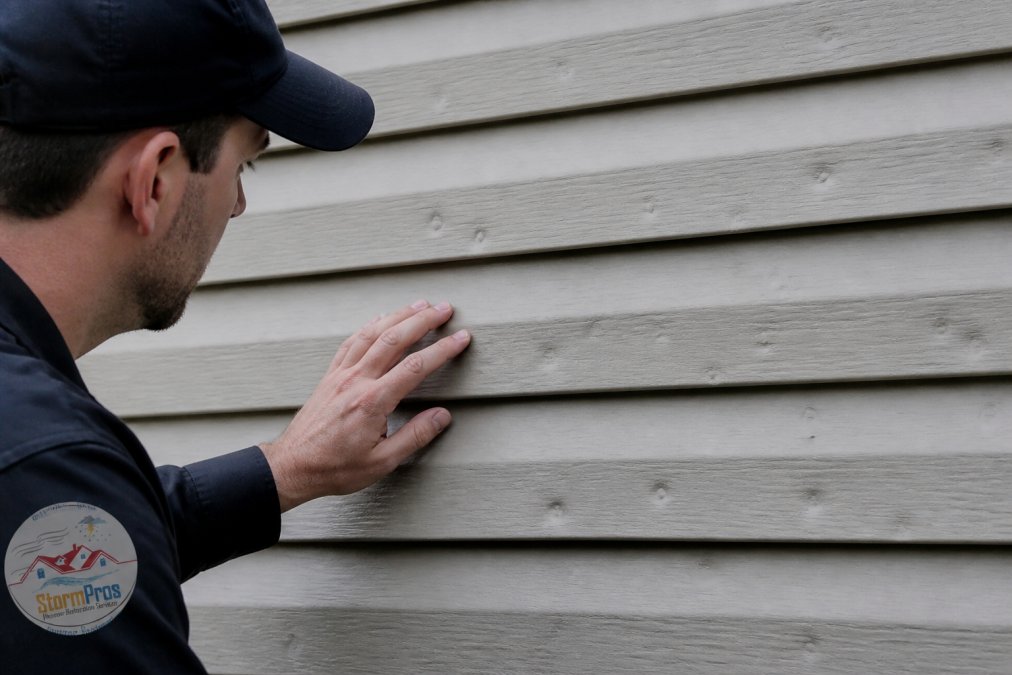 Infographic showing circular hail impact dents on vinyl siding to help you learn how to inspect siding after a storm.