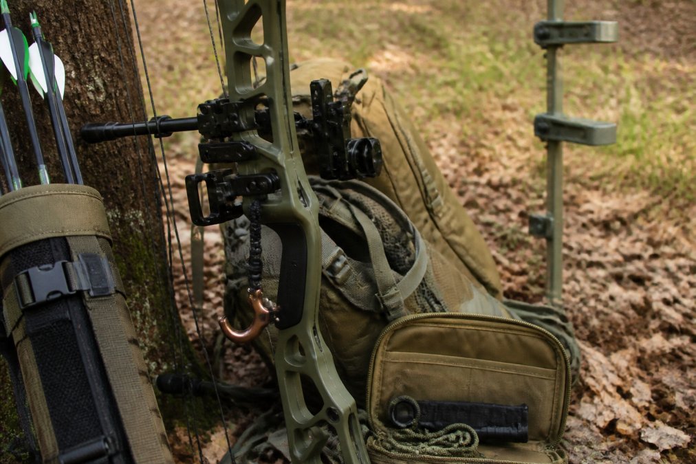 Compound bow with an integrated release aid, riser-mounted gear hook, and a balanced quiver for hunting.
