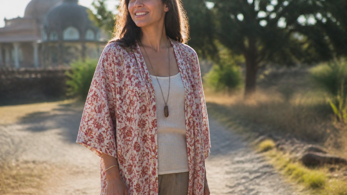 Woman wearing a hand block-printed cotton kaftan layered over a lightweight linen tank, standing outdoors in warm sunlight with a relaxed, casual pose