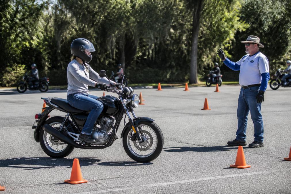 Beginner motorcyclist practicing slow-speed control with an instructor while you learn motorcycle riding skills.