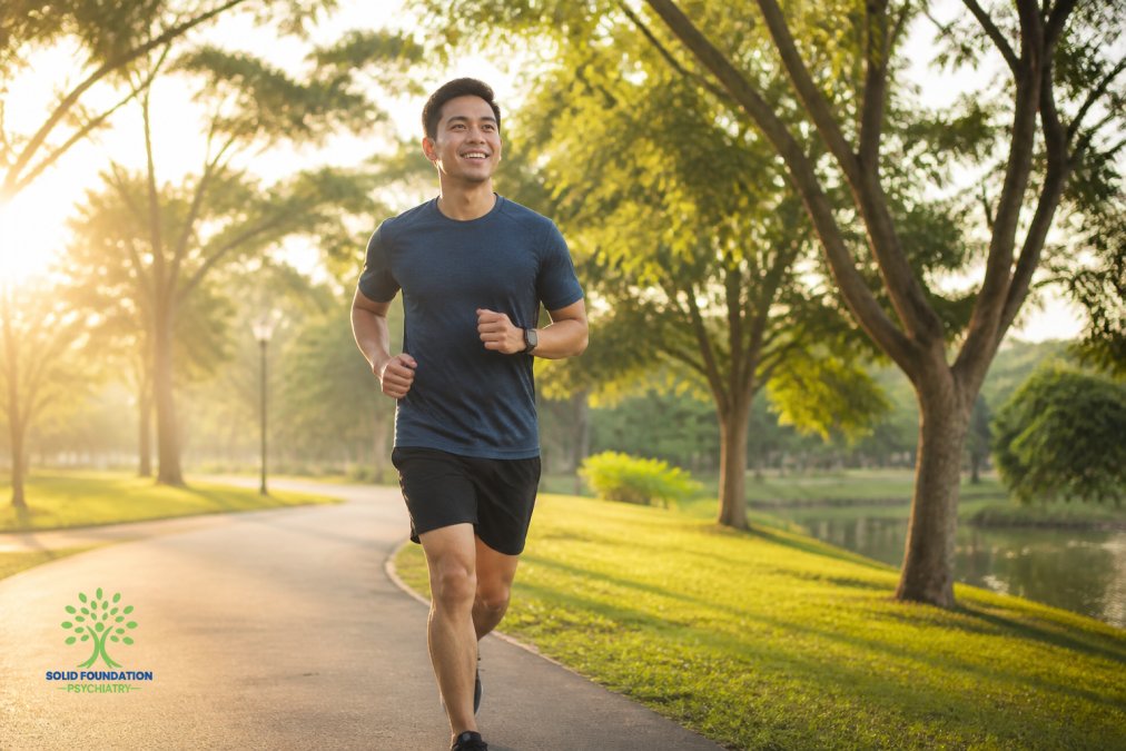 Person jogging outdoors in morning sunlight through a park, appearing calm and energized with natural light on their face