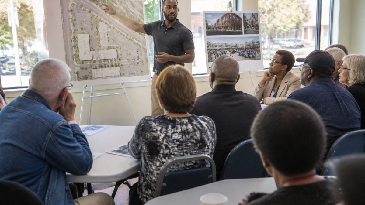 Developer presenting site plans to neighborhood residents during a community engagement meeting