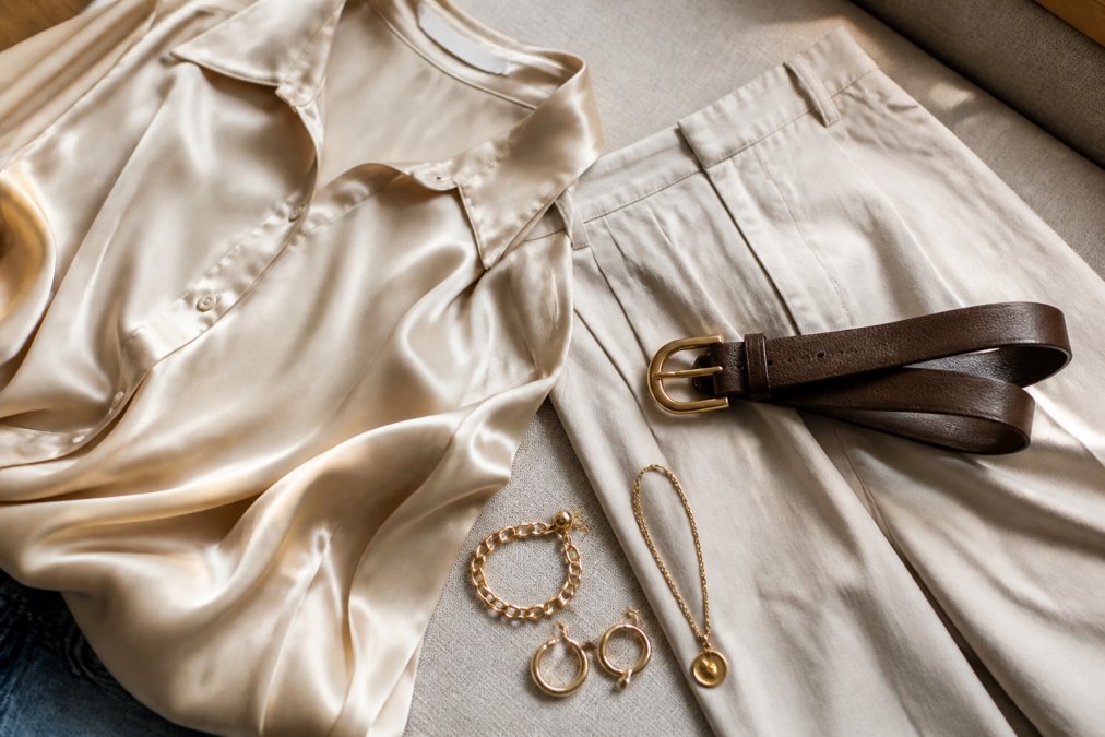 Silk designer blouse paired with affordable trousers and gold jewelry to show how to mix high-end and affordable fashion