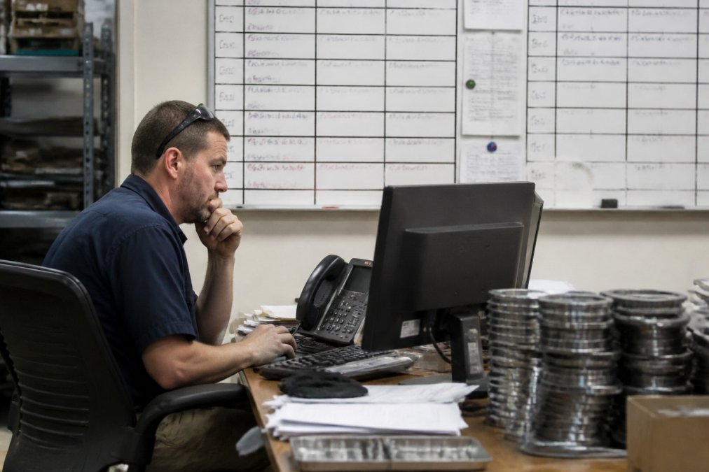 Manufacturing manager analyzing production data while hindered by outdated legacy manufacturing software