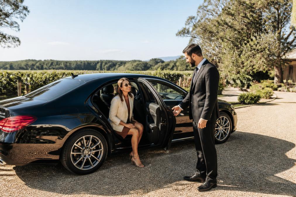 Chauffeur opening a luxury sedan door at a Hunter Valley wine tour estate