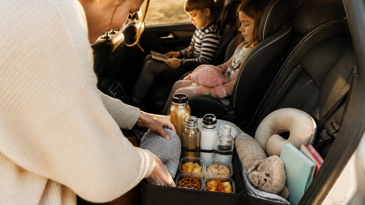 Family enjoying a stress-free family vacation with organized snacks and entertainment in a car.