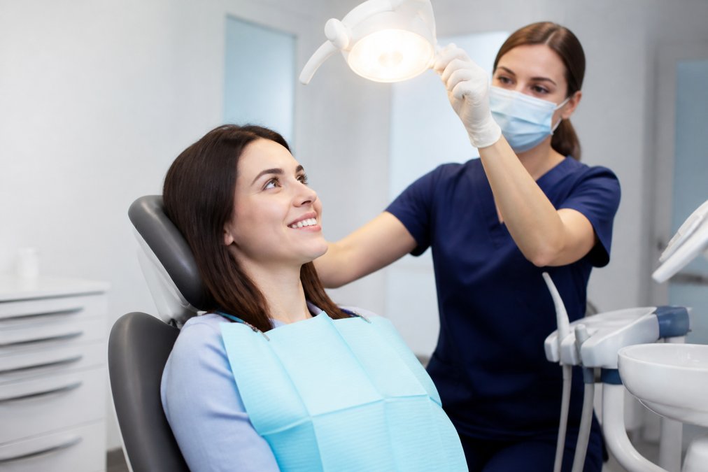 Calm patient smiling in a dental chair during a comfortable dental appointment with a nurse nearby