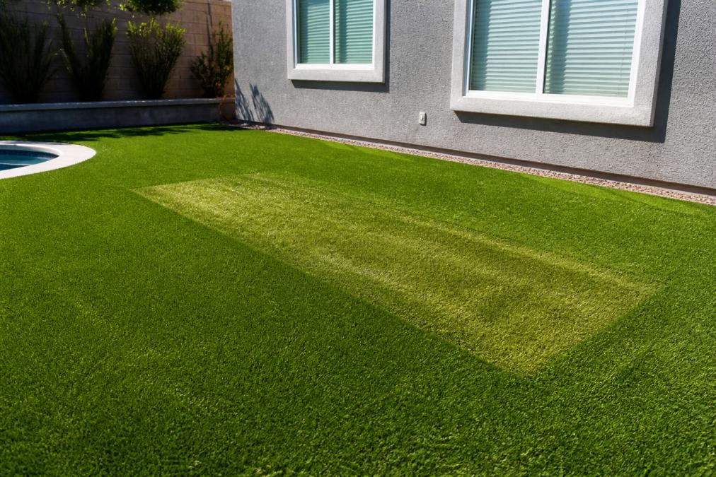 Diagram showing how window reflections cause artificial turf fading and melting on a backyard lawn.