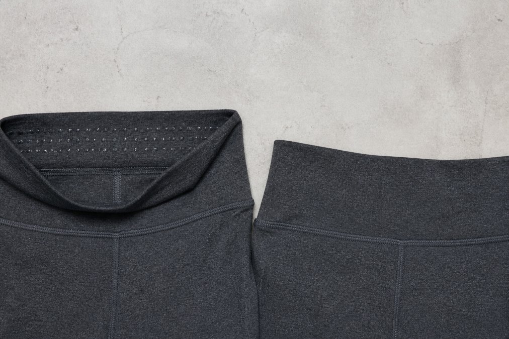 Close-up detail shot showing a high-waisted legging waistband with double-layer construction and silicone grip dots visible on the inner panel, positioned next to a flat single-layer waistband for direct comparison