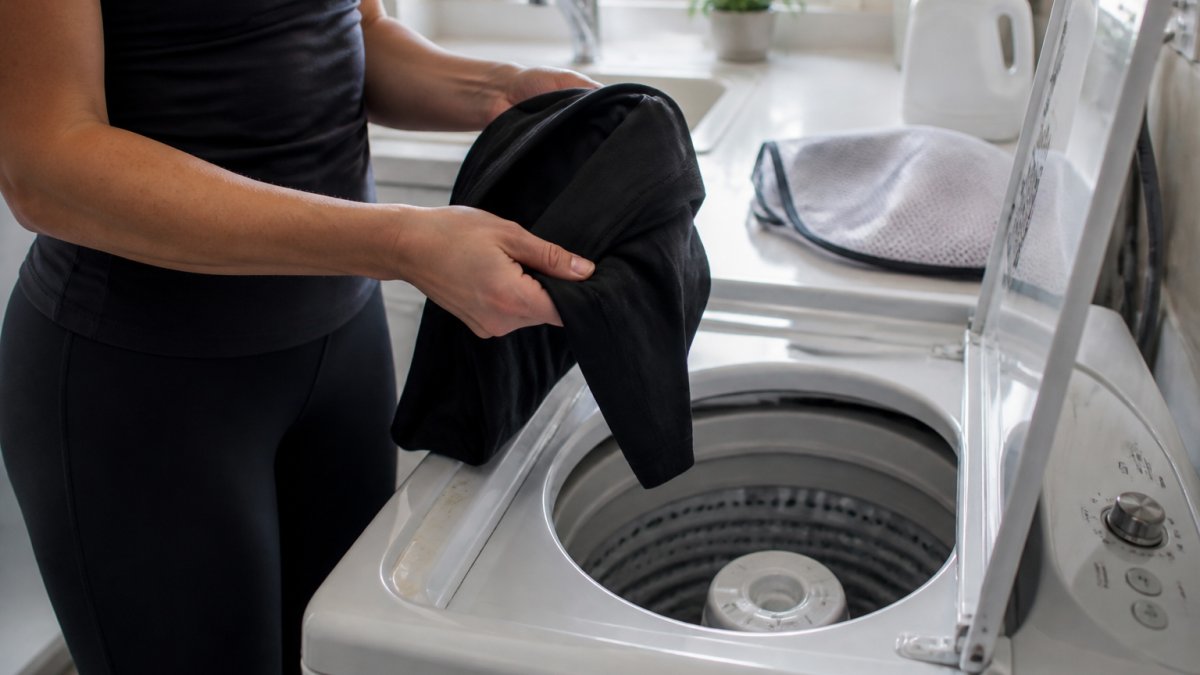 Person turning black leggings inside out before washing to prevent pilling