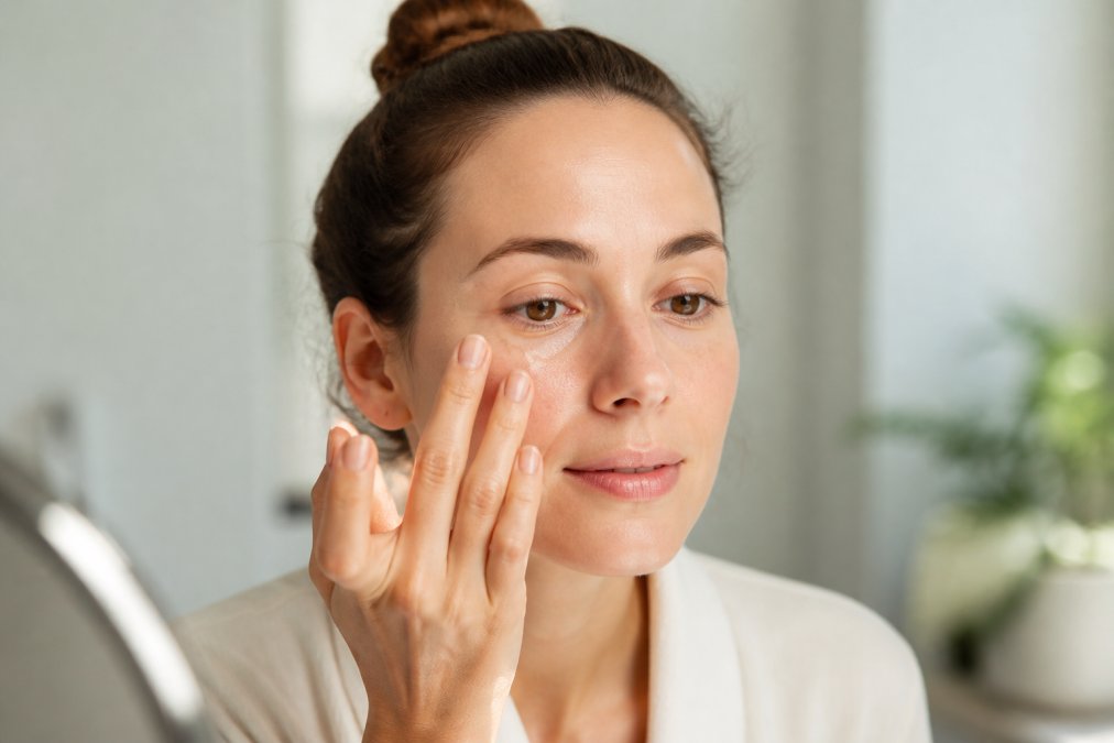 Step-by-step guide on applying eye serum with a gentle patting motion to reduce dark circles naturally