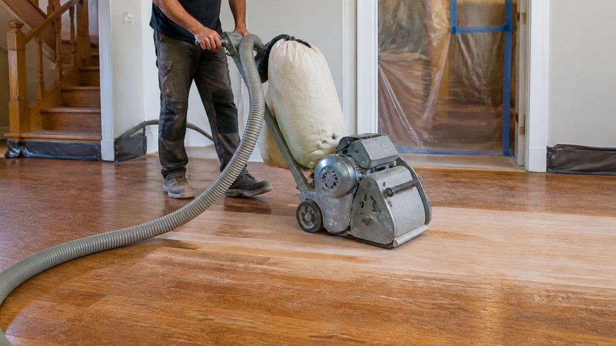 Step-by-step infographic showing how to refinish hardwood floors using a vacuum-assisted sander.